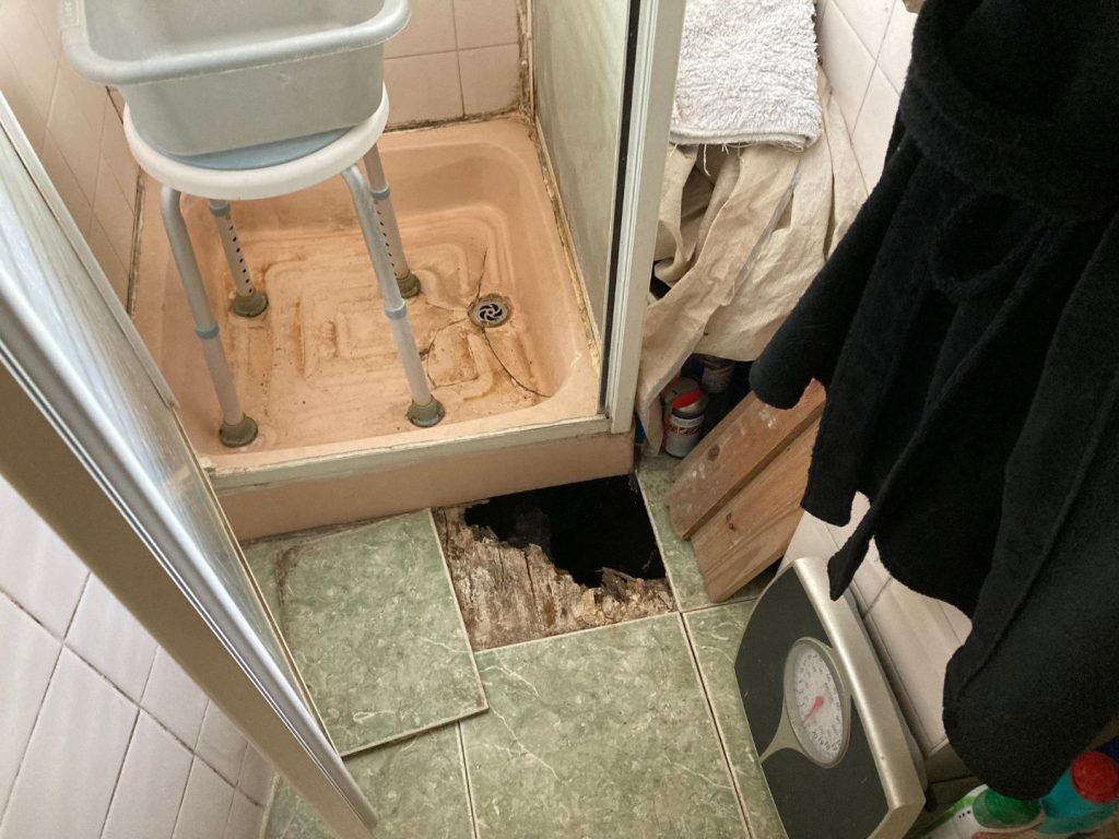 Old shower with a hole in the floor
